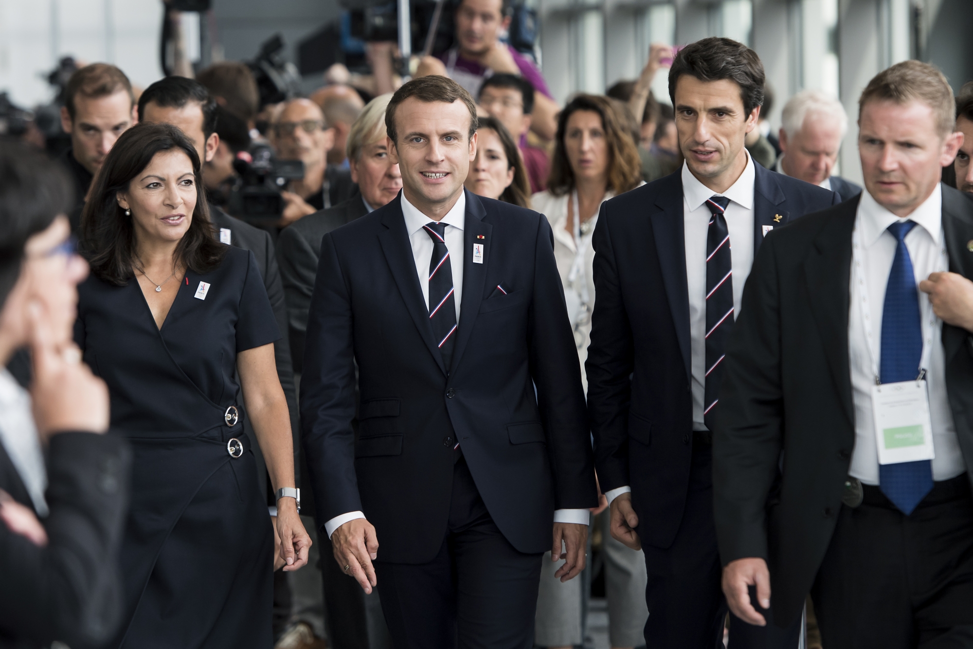 Emmanuel Macron entouré d'Anne Hidalgo, maire de Paris, et Tony Estanguet, champion olympique de canoë (KEYSTONE/Jean-Christophe Bott)