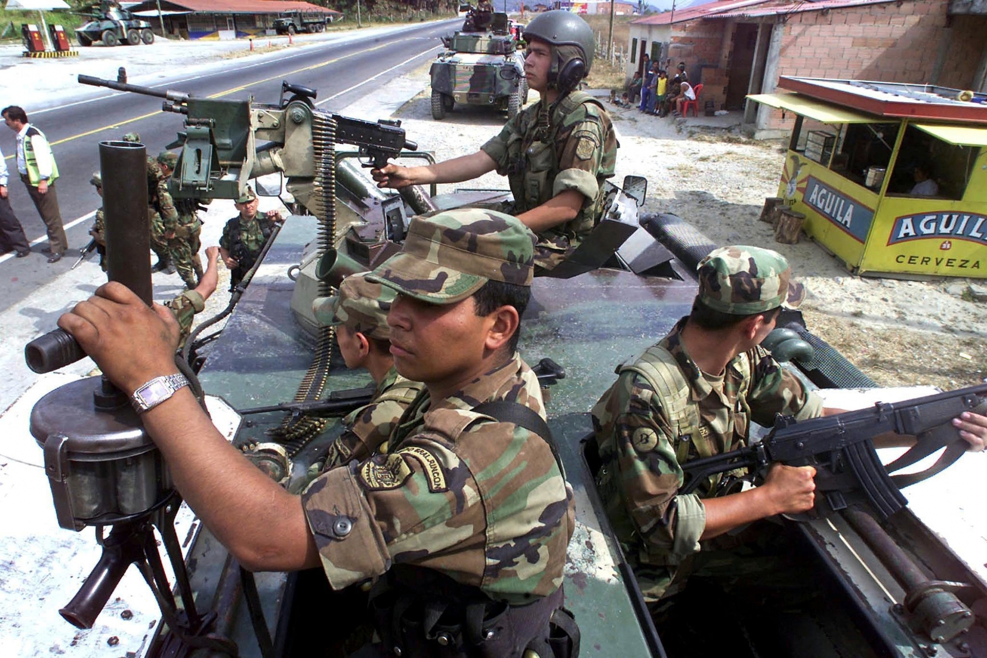 Colombian army soldiers guard 28 February, 2002, the road leading to Puente Quetame, 70kms from Bogota after reports that earlier in the day army troops had clashed with rebels from the Revolutionary Armed Forces of Colombia (FARC). The Colombian government has granted the army extended authority, including control of public safety, in six departments nationwide to counter the recent wave of rebel attacks, Defense Minister Gustavo Bell announced Thursday. The statement comes as guerrillas strike power lines on the border with Venezuela, leaving an oil-producing region in the dark, and Colombia's top military brass claims devastating casualties following aerial bombardment on rebel targets.   AFP PHOTO/Rodrigo ARANGUA COLOMBIA-OFFENSIVE-ARMY