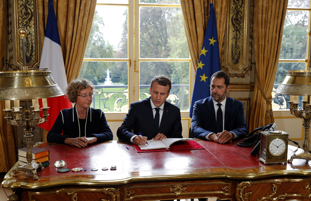 Emmanuel Macron a paraphé les documents à l'Elysée, sous les yeux de la ministre du travail Muriel Penicaud et du porte-parole du gouvernement Christophe Castaner.