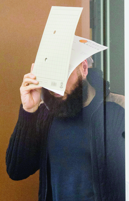 Abu Walaa  covers his face as he arrives at the High Regional Court of Celle, Germany, Tuesday, Sept.. 26, 2017. The 33-year-old Iraqi citizen and four fellow suspects are accused of membership in a terrorist organization, terror financing and public incitement to commit crimes. Abu Walaa, allegedly recruited young Muslims in Germany, and raised funds to send them to Syria and Iraq to join IS. (Julian Stratenschulte/dpa via AP) Germany Islamic State