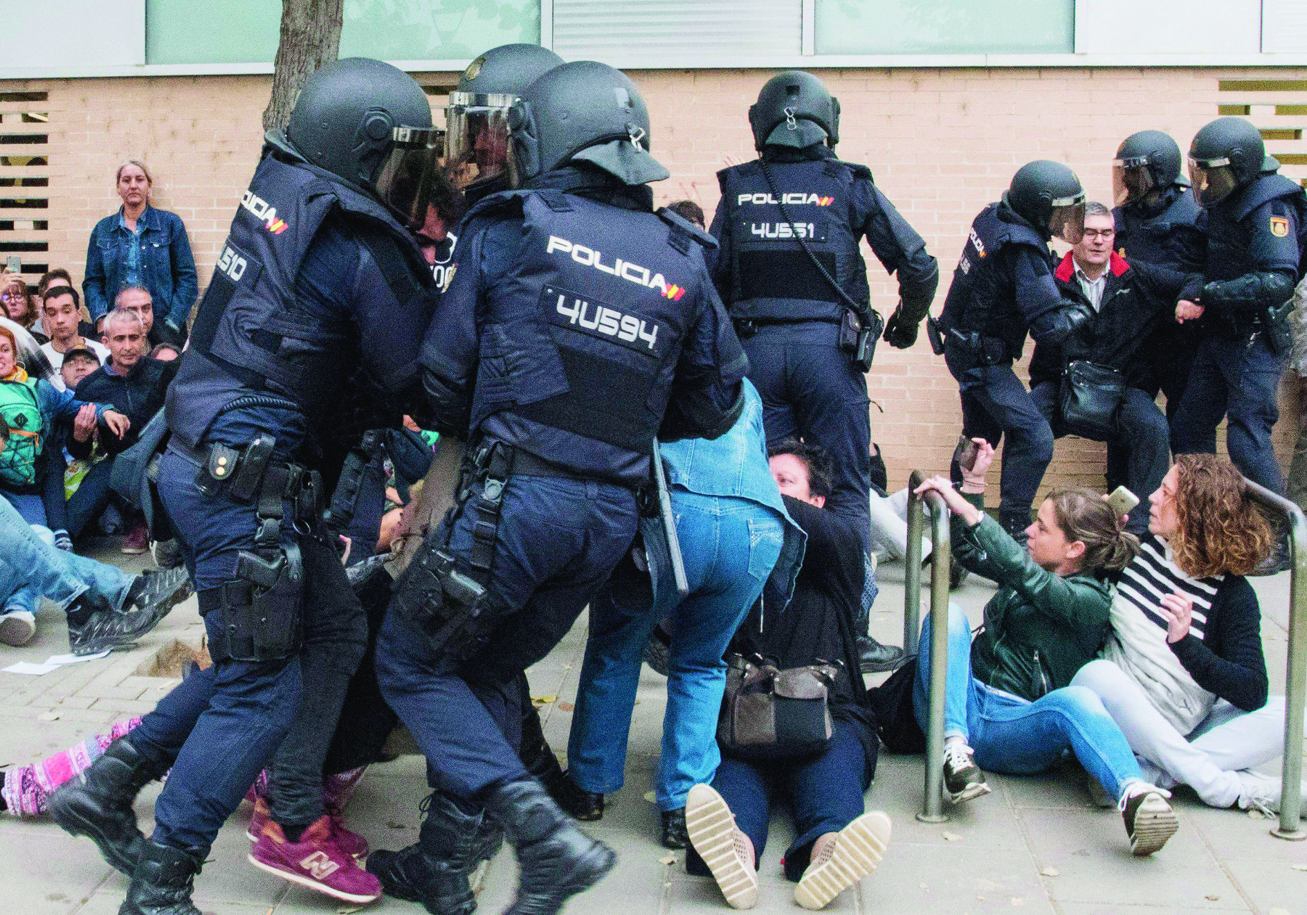 epa06237424 Catalan people clash with police outside at a polling center set at a health clinic clash with Spanish National Police officers after police forces seized ballot boxes during the '1-O Referendum' in Cappont, Lleida, Catalonia, northeastern Spain, on 01 October 2017. National Police officers and Civil guards have been deployed to seize voting material and to prevent the people from entering to the polling centers and vote in the Catalan independence referendum, that has been banned by the Spanish Constitutional Court, what has provocked clashes between pro-independence people and the police forces in some polling centers.  EPA/Adria Ropero SPAIN CATALONIA REFERENDUM