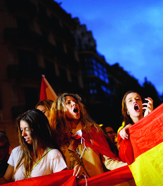 Anti-independence demonstrators waving Spanish flags shout slogans during a protest in Barcelona, Wednesday, Oct. 4, 2017. Catalonia's regional government is mulling when to declare the region's independence from Spain in the wake of a disputed referendum that has triggered Spain's most serious national crisis in decades. (AP Photo/Francisco Seco) Spain Catalonia