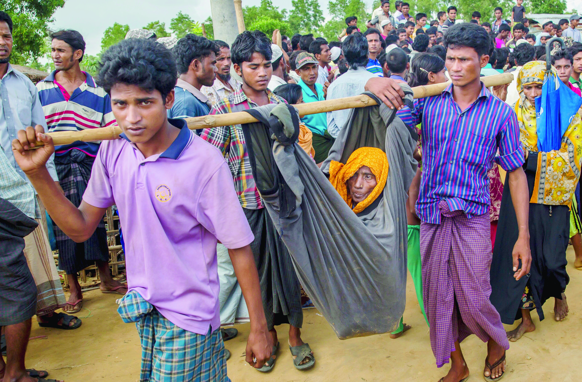 Rohingya Muslim men, who crossed over from Myanmar into Bangladesh, carry their mother in a cloth tied to bamboo stick at Kutupalong refugee camp, Bangladesh, Monday, Oct. 23, 2017. U.N. humanitarian officials, high-level government envoys and advocacy group leaders on Monday opened a one-day conference aimed at drumming up funds to help ethnic Rohingya refugees in Bangladesh, as the influx from Myanmar has topped 600,000 since late August. (AP Photo/Dar Yasin) Bangladesh Myanmar Attacks