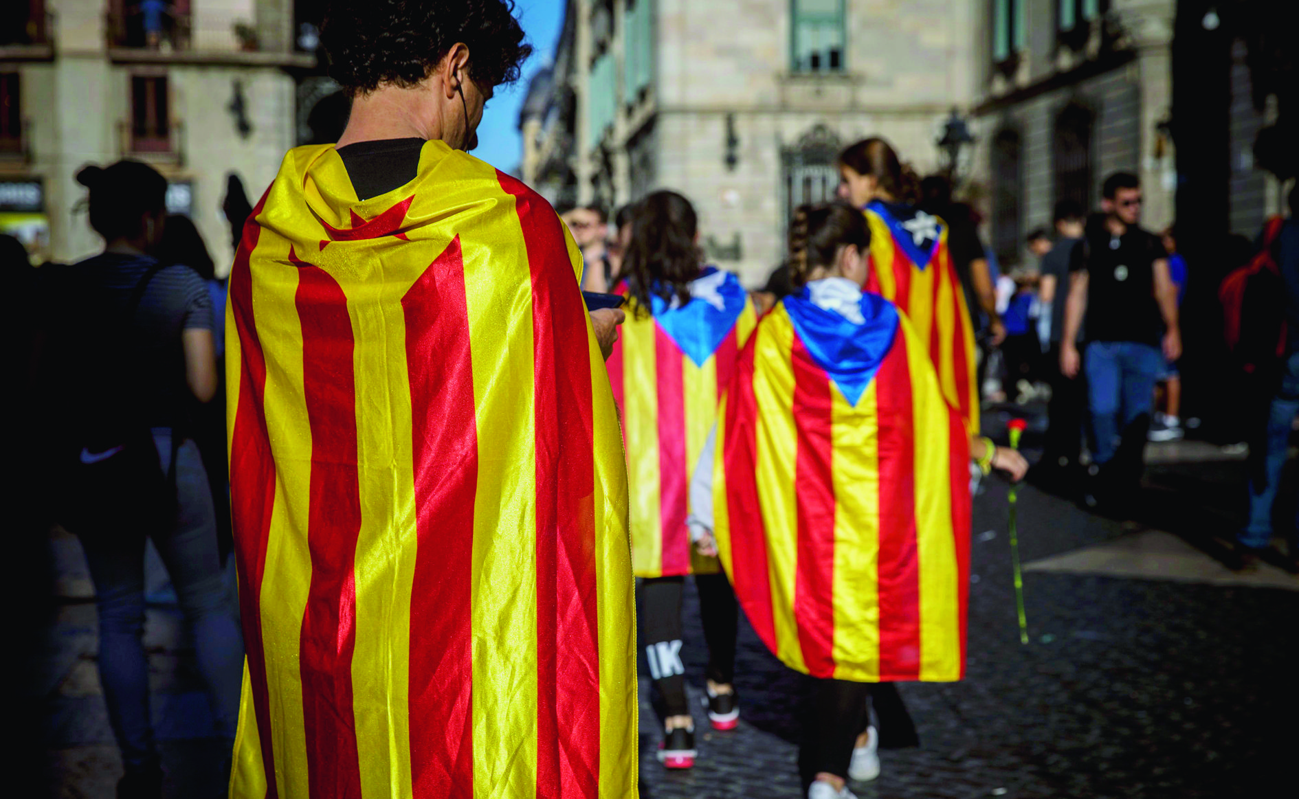 People draped in independence flags gather outside the Generalitat Palace, in Barcelona, Spain, Thursday, Oct. 26, 2017. Puigdemont said Thursday he considered calling a snap election, but was choosing not to because he didn't receive enough guarantees that the government's "abusive" moves to take control of Catalonia would be suspended. (AP Photo/Santi Palacios) Spain Catalonia