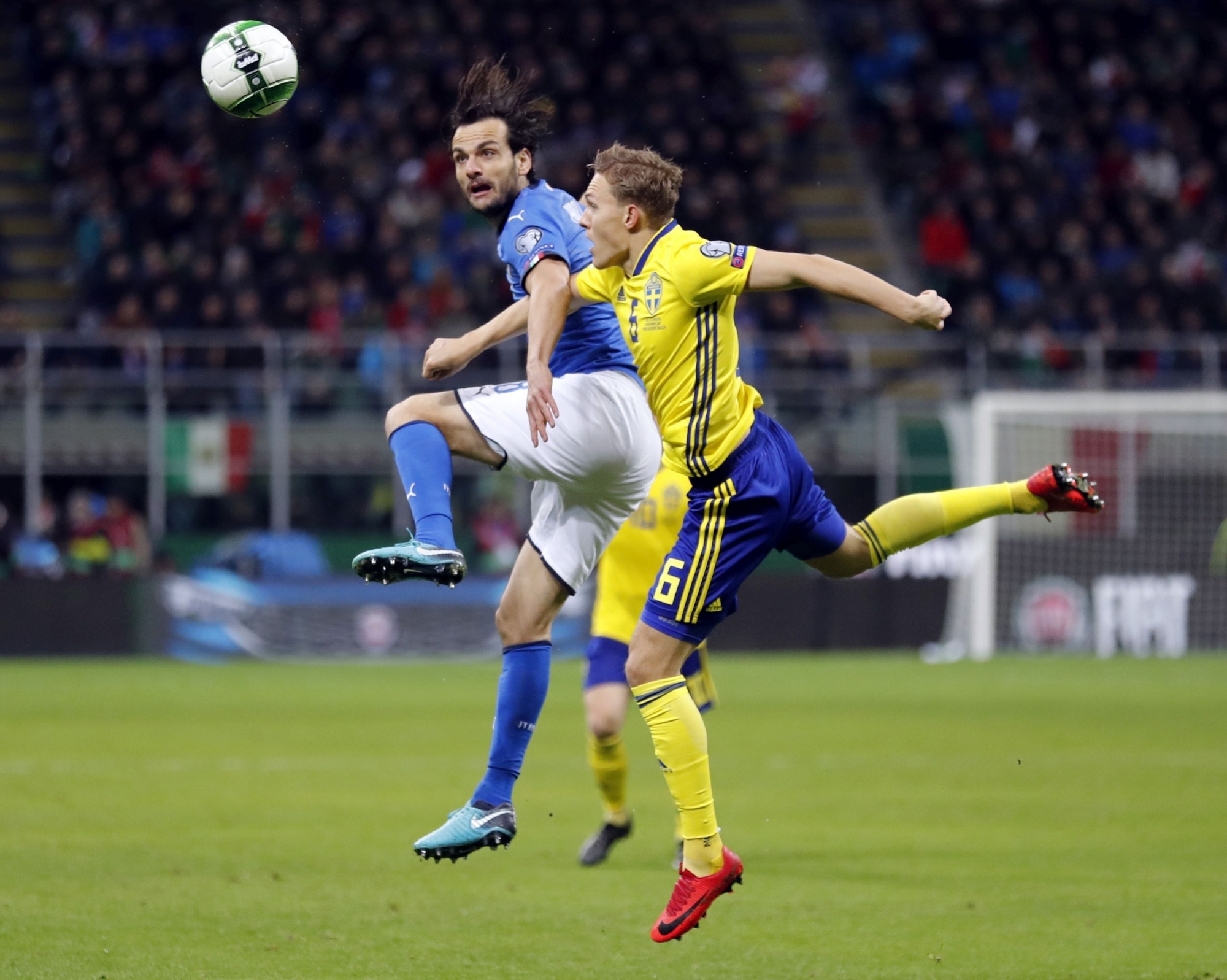 Sweden's Ludwig Augustinsson, right, and Italy's Marco Parolo jump for the ball during the World Cup qualifying play-off second leg soccer match between Italy and Sweden, at the Milan San Siro stadium, Italy, Monday, Nov. 13, 2017. (AP Photo/Antonio Calanni)