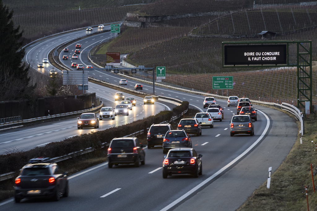 Des voitures circulent sur l'autoroute A9 a cote d'un panneau d'information avec le message de prevention contre l'alcool au volant "boire ou conduire, il faut choisir" ce dimanche 31 decembre 2017 a Montreux. (KEYSTONE/Jean-Christophe Bott)