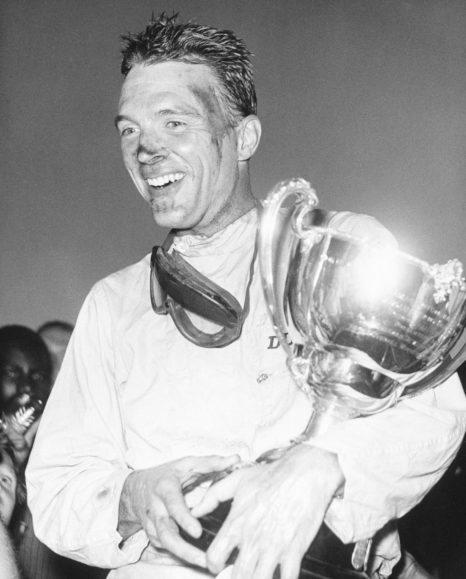 FILE - This Dec. 9, 1962 file photo shows Dan Gurney holding a trophy in Nassau, Bahamas. Gurney, the first driver to win in Formula One, IndyCar and NASCAR, died Sunday, Jan. 14, 2018 from complications of pneumonia. He was 86. His wife, Evi, announced his death in a statement distributed by All American Racers, Inc. (AP Photo) OBIT-GURNEY