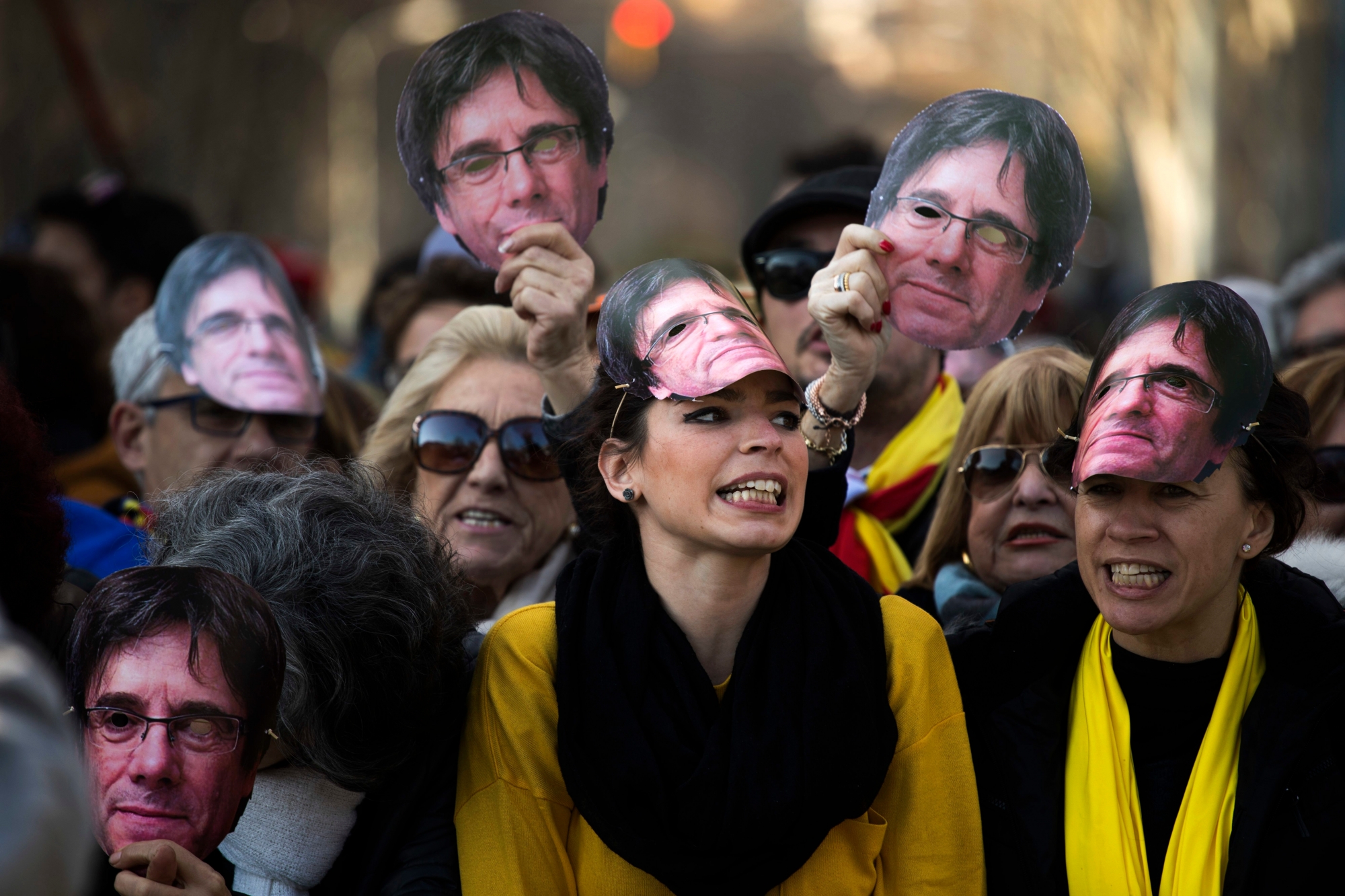 Demonstrators wearing masks of Catalonia's ex-president Carles Puigdemont shout slogans during a protest outside the Catalonia parliament in Barcelona, Spain, Tuesday, Jan. 30, 2018. Plans by Catalan separatist lawmakers to re-elect fugitive ex-president Tuesday received a setback when the house speaker postponed the session, saying the planned parliament meeting would not take place until there were guarantees Spanish authorities "won't interfere." (AP Photo/Emilio Morenatti) Spain Catalonia