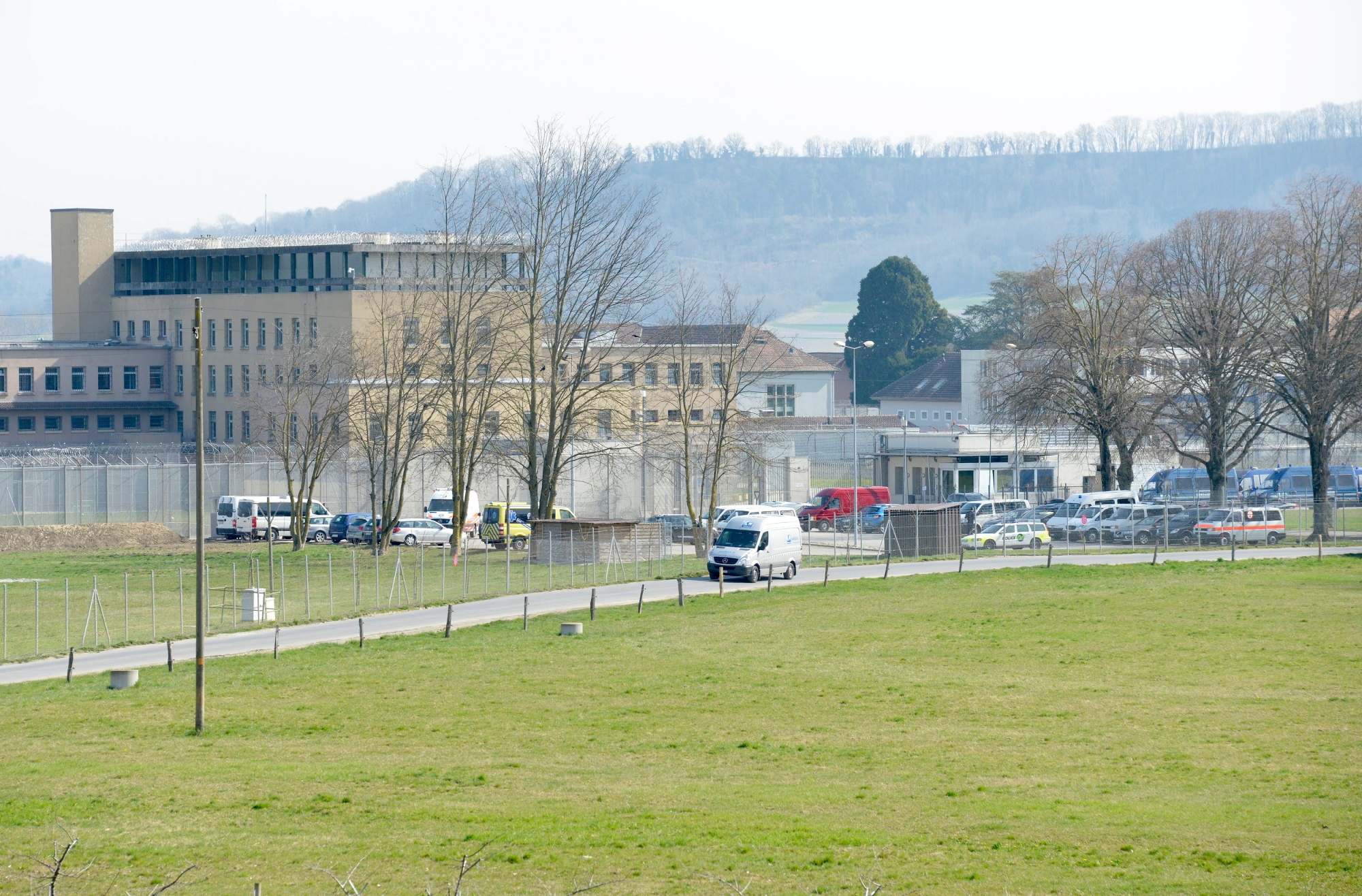 Des policiers bloquent l'acces a la prison de Bochuz lors d'une operation de securite de la police vaudoise ce mardi 18 mars 2014 aux Etablissements de la plaine de l'Orbe (EPO) a Orbe, Vaud. Une operation preventive de securite, visant a "garantir sur le long terme la securite du personnel et des personnes detenues" a debute mardi a 6h au penitencier vaudois de Bochuz. (KEYSTONE/Christian Brun) SCHWEIZ GEFAENGNIS BOCHUZ POLIZEI RAZZIA