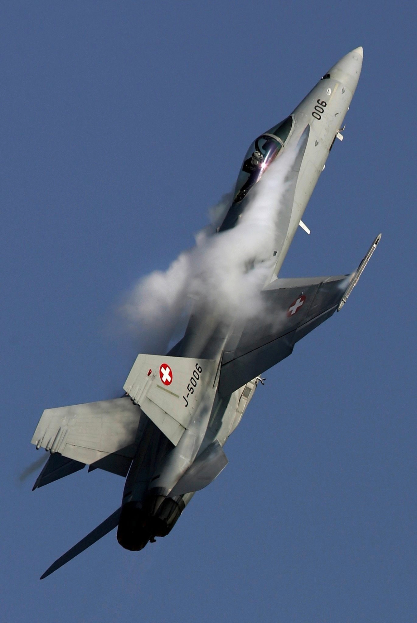 A F/A 18 jet of the Swiss Air Forces shows vaporisation effect due to the speed, during a demonstration flight at the airshow Air 04 in Payerne, September 5, 2004. The airshow is one of the biggest in Europe this year, showing top international and national flying teams. Swiss Air Force takes the opportunity to celebrate the 90th anniversary of the founding of the Swiss Air Force and the 40th anniversary of their acrobatic jet team Patrouille Suisse.  (KEYSTONE/Fabrice Coffrini) SWITZERLAND AIR SHOW
