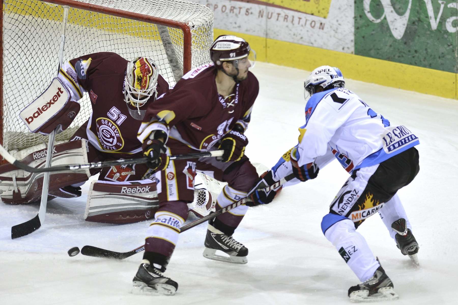 Le joueur de Fribourgeois Greg Mauldin, droite, a la lutte pour le puck avec le joueur Genevois Julian Walker, centre, devant le gardien genevois Tobias Stephan, gauche, lors du match du championnat suisse de hockey sur glace de National League LNA, entre le Geneve Servette HC et le HC Fribourg-Gotteron, ce vendredi 23 novembre 2012 a la patinoire des Vernets a Geneve. (KEYSTONE/Martial Trezzini)