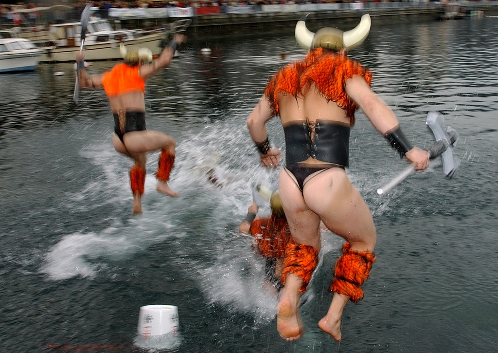 Des vickings se jettent a l'eau dans le Lac Leman ce dimanche 15 decembre 2002 dans la rade de Geneve. Plus de 550 nageurs se sont elances pour la traditionnelle coupe de Noel, sur un parcours de 150 metres, la temperature de l'eau et de l'air etait de 6 degres. (KEYSTONE/Martial Trezzini)