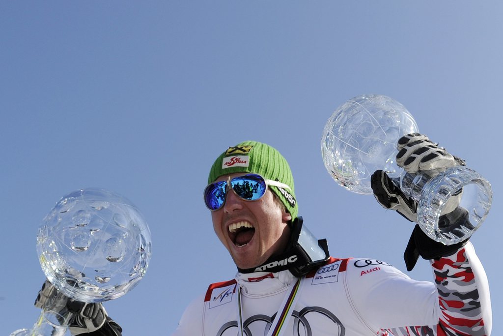 Austrian Marcel Hirscher celebrates in the finish area holding the crystal globe of the winner of the Overall standing at the Alpine Ski World Cup finals, in Schladming, Austria, Sunday, March 18, 2012. (KEYSTONE/Jean-Christophe Bott)