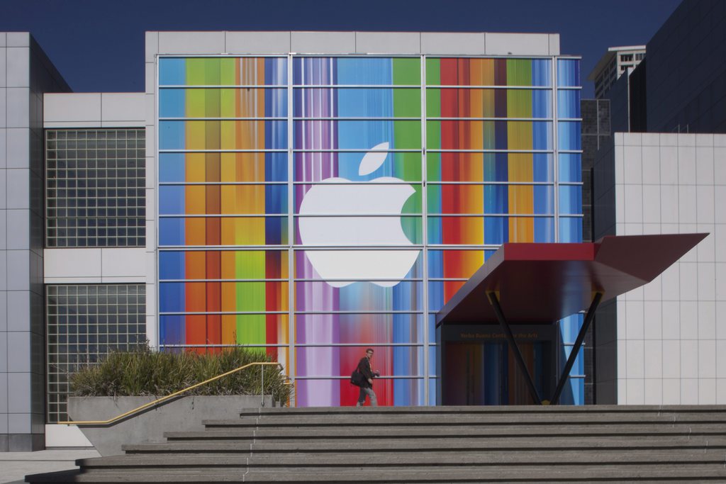epa03391629 A pedestrian strolls past the Apple logo adorned front facade of the Yerba Buena Center for the Arts in San Francisco, California, USA, 09 September 2012, three days before the anticipated iPhone 5 announcement will be made.  EPA/PETER DaSILVA