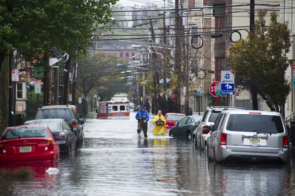 Residents walk through flood water and past a stalled ambulance in the  aftermath of superstorm Sandy on Tuesday, Oct. 30, 2012 in Hoboken, NJ. (AP Photo/Charles Sykes)
