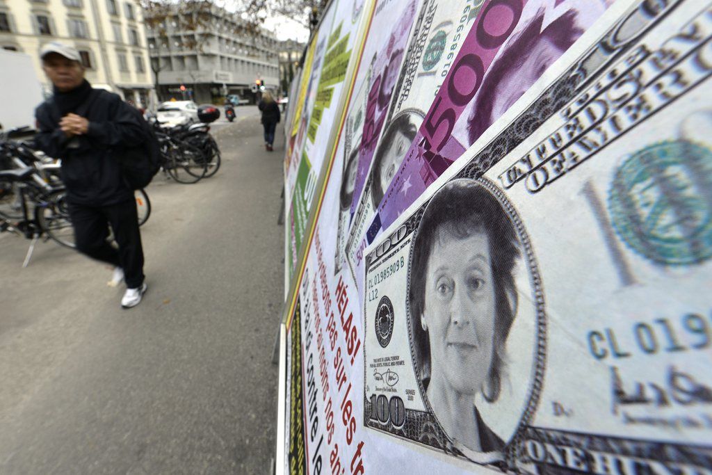 Une personne passe devant l'affiche du MCG qui utilise la tete d'Eveline Widmer-Schlumpf sur des billets de banque afin d'illustrer les prochaines votations de dimanche 25 novembre 2012 et le theme de la loi contre les epizooties ce vendredi 16 novembre 2012, a Geneve. Le slogan c'est "Les vaccins protegent? mais pas contre tout! Helas! Nous ne voterons pas sur les traites fiscaux. Preservons au moins nos animaux. Oui a la loi contre les epizooties." (KEYSTONE/Martial Trezzini)..