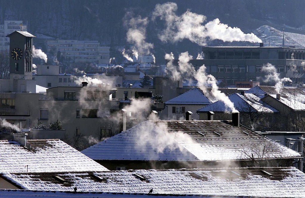 Der Kaelteeinbruch vom Dienstag, 25. Januar 2000, mit massiven Minusgraden laesst die Schornsteine ueber den Daechern von Chur rauchen. (KEYSTONE/Arno Balzarini)  === ELECTRONIC IMAGE ===