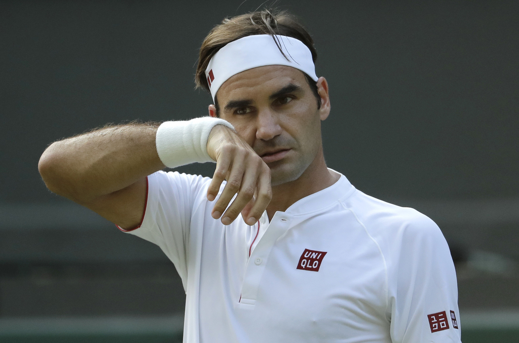 Switzerland's Roger Federer wipes his face during his men's singles match against Germany's Jan-Lennard Struff, on the fifth day of the Wimbledon Tennis Championships in London, Friday July 6, 2018. (AP Photo/Ben Curtis)