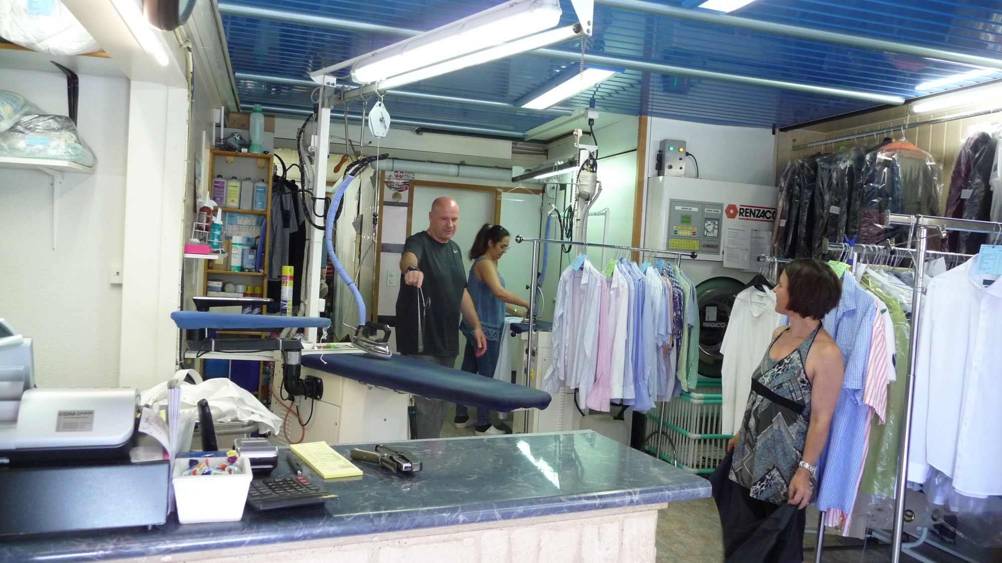 João Costa avec deux de ses employées dans la partie pressing de son magasin de Saint-Prex