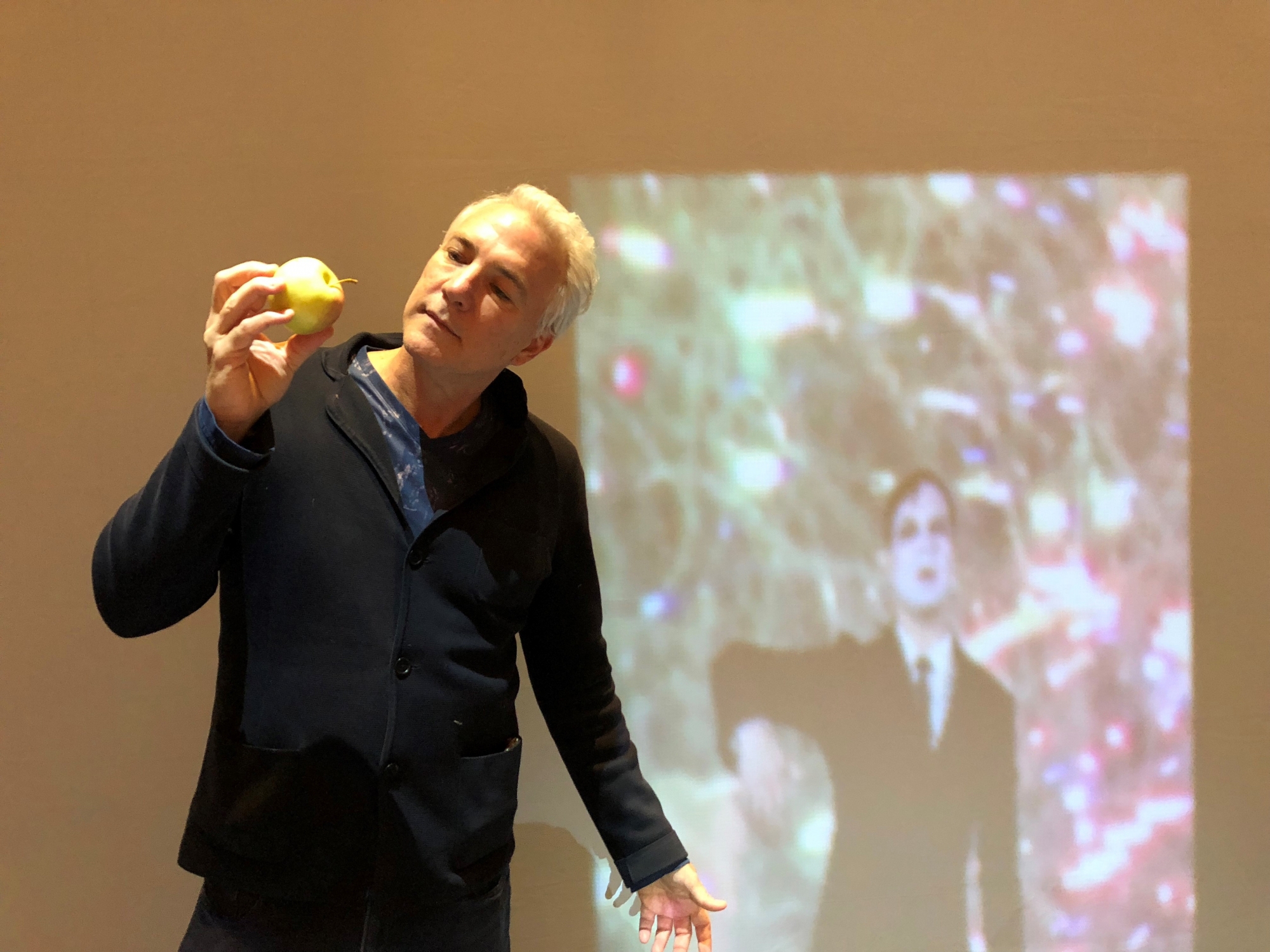 Raphaël Castoriano pose, scientifiquement, devant les projections de Tony Oursler.