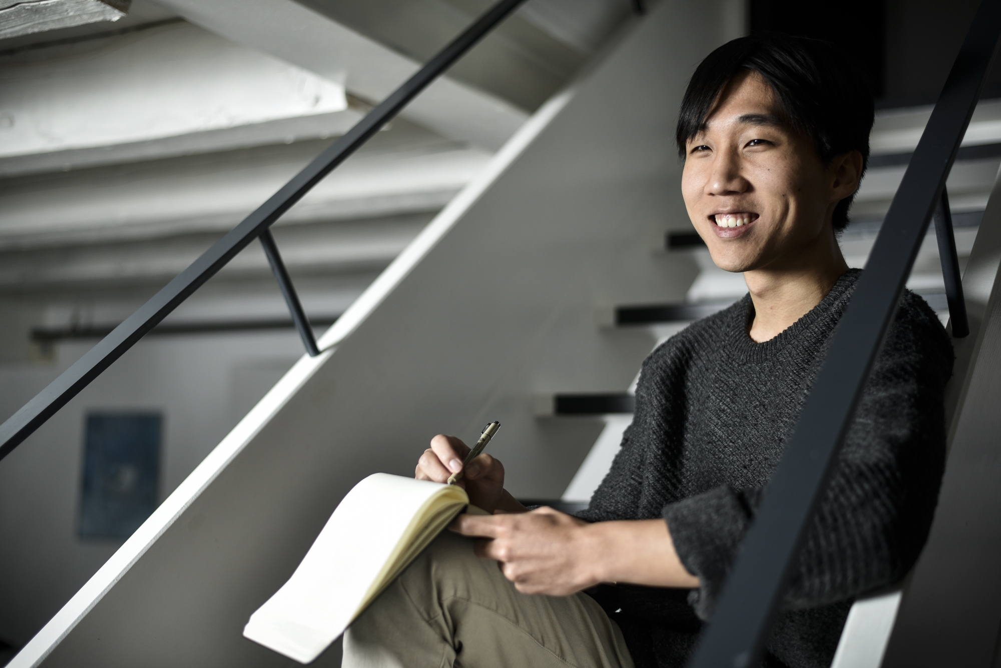 Damien Cho note ses idées dans un carnet, puis réalise ses dessins à l'aide d'une tablette numérique.