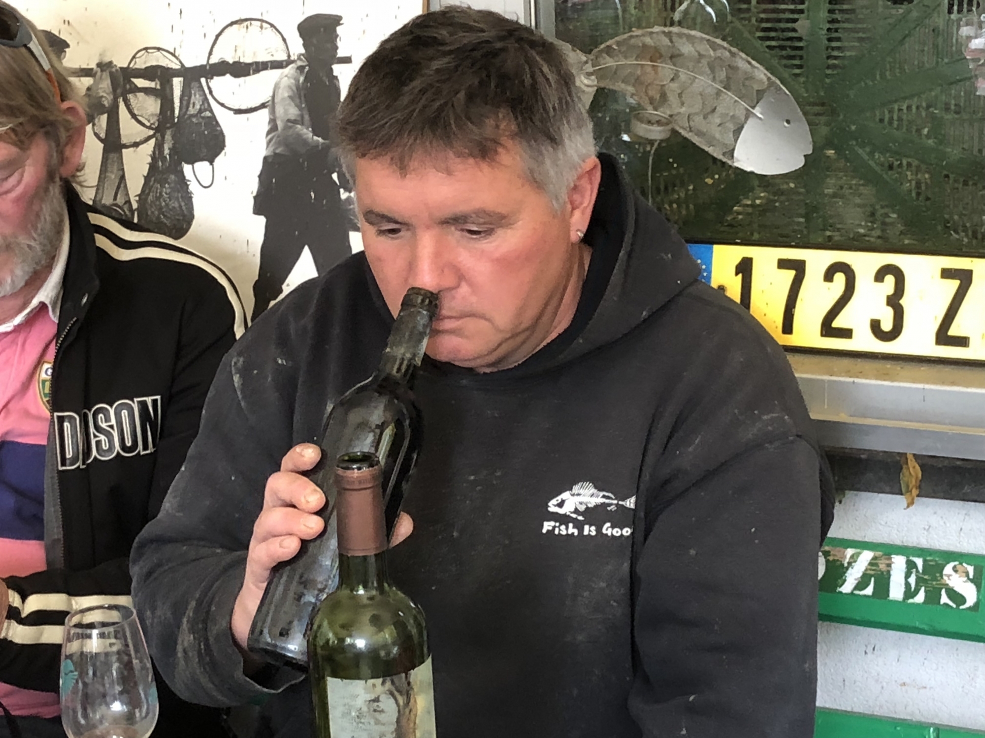 Le pêcheur Manu Torrent au moment d'ouvrir la deuxième des bouteilles émergées du Léman où elles reposaient par 20 mètres de fond.