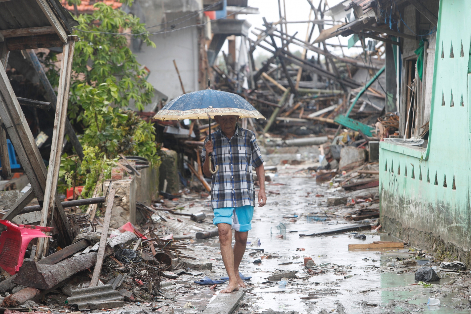 epa07248151 Local residents walk among debris in devastated area after a tsunami hit Sunda Strait in Sumur, Banten, Indonesia, 25 December 2018. According to the Indonesian National Board for Disaster Management (BNPB), at least 429 people died and 1,459 others have been injured after a tsunami hit the coastal regions of the Sunda Strait.  EPA/ADI WEDA INDONESIA TSUNAMI