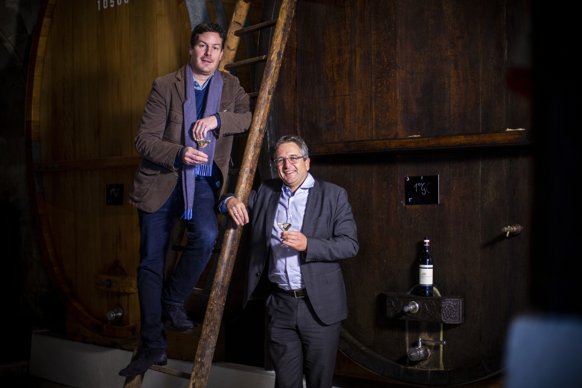 Sur l'échelle, François Schenk, descendant des fondateurs du groupe vinicole savoure un premier grand cru issu du fleuron de la maison Schenk, le Château de Châtagneréaz avec André Fuchs, directeur des activités en Suisse.