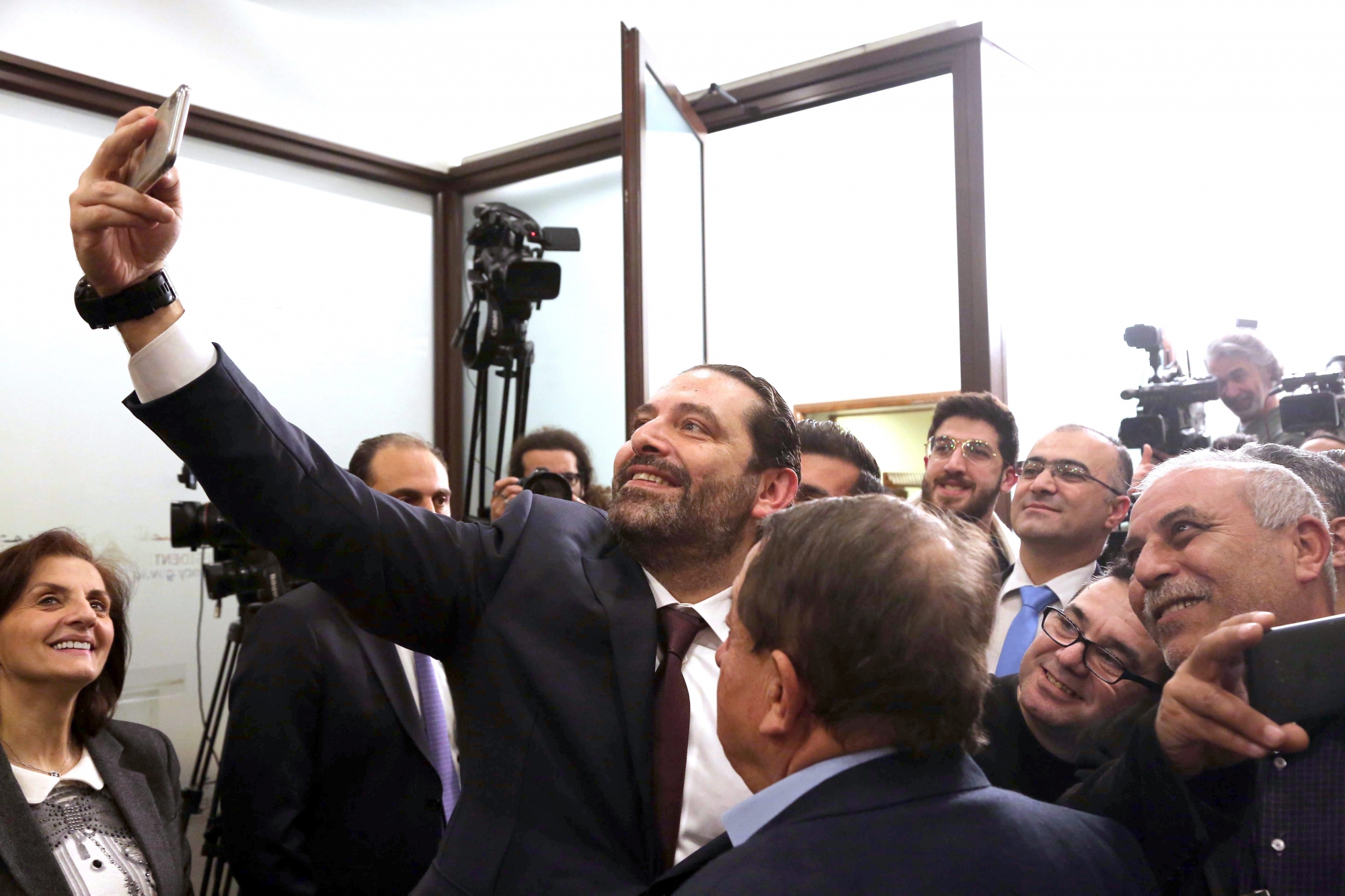 epa07334250 Lebanese Prime Minister Saad Hariri (L) takes a selfie with journalists at the Presidential Palace in Baabda, east Beirut, Lebanon, 31 January 2019. Lebanon announced a government on 31 January after an eight-month stalemate since the elections in 06 May 2018.  EPA/WAEL HAMZEH LEBANON GOVERNMENT