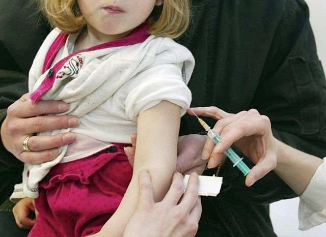 Une petite fille de deux ans se fait vacciner. 