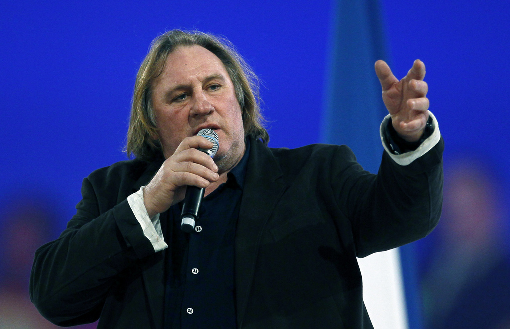 French actor Gerard Depardieu waves to support President and candidate for the upcoming re-election, Nicolas Sarkozy during a meeting in Villepinte, north of Paris, France, as part of his electoral campaign, Sunday March 11, 2012. (AP Photo/Francois Mori)