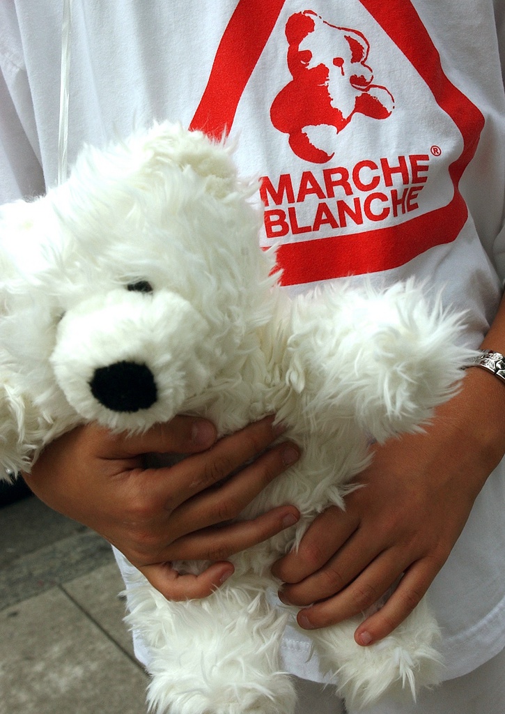 Une jeune fille tiens un nounours pres de son Tee-shirt avec le logo de la marche blanche,  plusieurs centaines de personnes ont defilent lors de la Marche Blanche, ce samedi 27 septembre 2003 a Geneve. Plusieurs centaines de personnes et de motard ont participe ce samedi a la Marche blanche pour exiger un renforcement de la lutte contre la pedophilie. Les manifestants ont defile vetus de blanc dans 12 villes de toute la Suisse a la troisieme Marche Blanche contre la pedocriminalite. Le concept de cette marche a ete repris des rassemblements organises en Belgique a la suite de l'affaire Dutroux. Outre des defiles silencieux dans les rues, les points forts ont ete constitues par des lachers de ballons blancs et des discours touchants.
(KEYSTONE/Martial Trezzini)