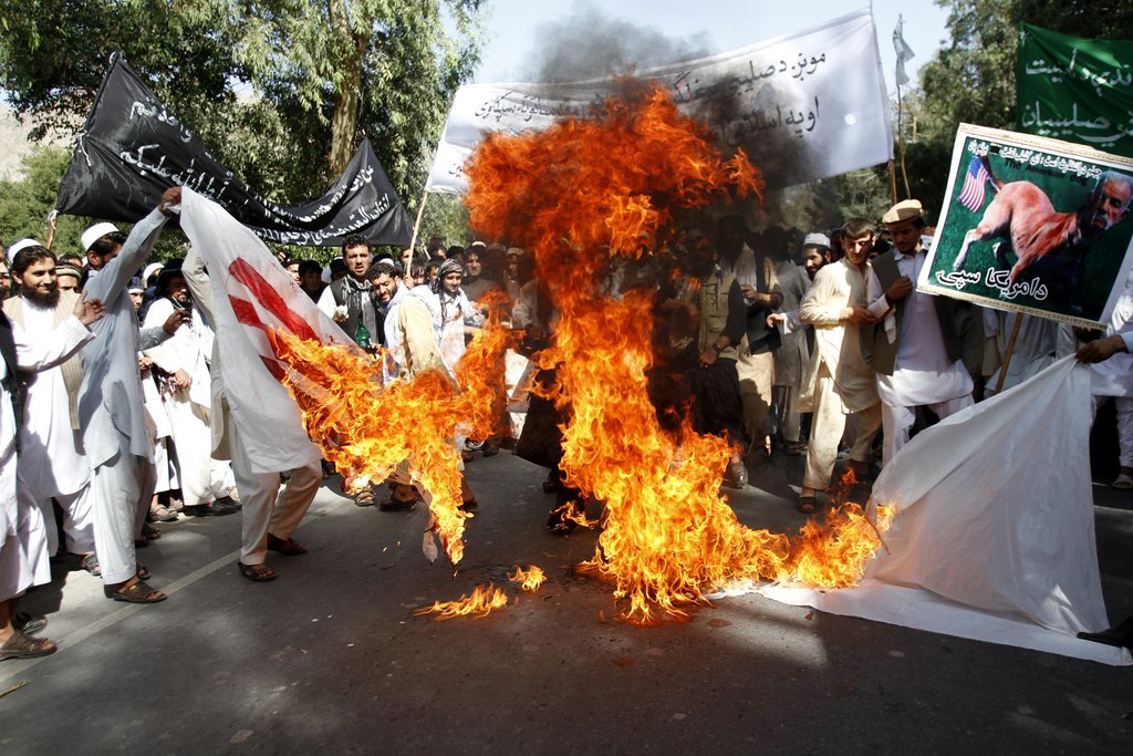 Afghan university students burn a U.S. flag  in Surkhrod  district of Nangarhar province, east of Kabul, Afghanistan, Wednesday, Sept 19, 2012. Hundreds of Afghans, some shouting "Death to America",   held a protest against an anti-Islam film in the eastern city of Jalalabad. (AP Photo/Rahmat Gul)