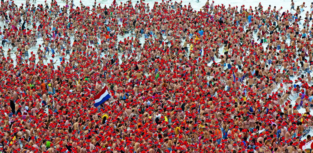 epa03521631 People dive collectively into the North Sea during the Nieuwjaarsduik, or New Year's dive in English, on New Year's Day in Scheveningen, in the Netherlands, 01 January, 2013.  EPA/ROBIN UTRECHT