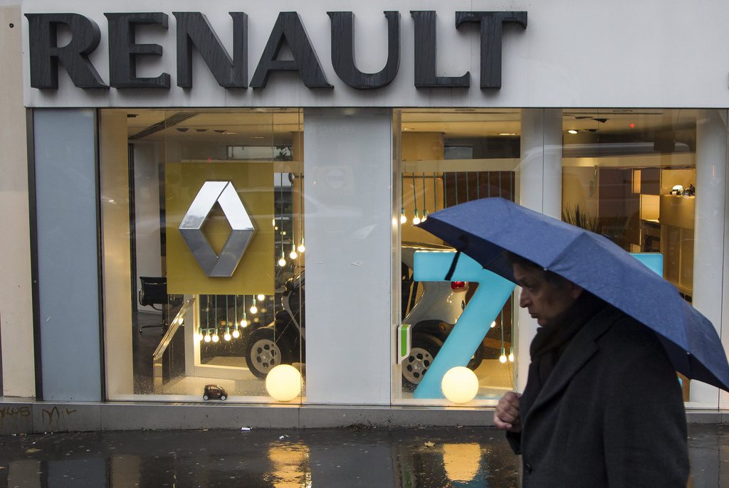 epa03537249 (FILE) A file picture  dates 14 December 2012 showing a pedestrian with an umbrella walking past a by French automobile manufacturer Renault dealership in Paris, France. Renault has announced on 15 January 2013 that the car manufacturer plans to cut 7,500 jobs amongst its staff by 2016, representing around 14 per cent of its staff, in a bid to boost competitiveness amid the economic slump in the European automobile industry,.  EPA/IAN LANGSDON