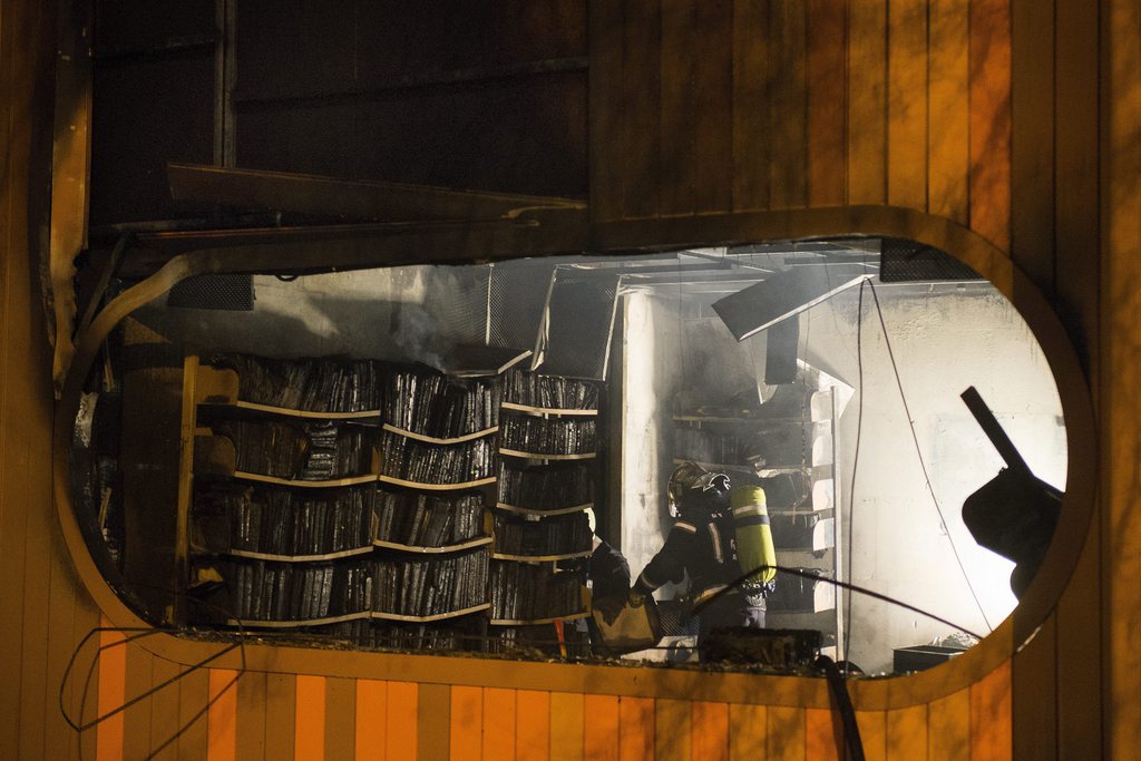 Un pompier travail sur l'incendie de la bibliotheque municipale de Lausanne ce dimanche 20 janvier 2013 a Lausanne. (KEYSTONE/Jean-Christophe Bott)