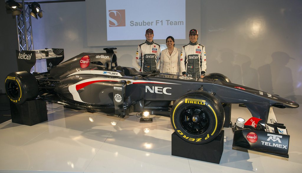Sauber F1 Team Formula One drivers Nico Huelkenberg of Germany, from left, Monisha Kaltenborn, CEO of Sauber F1 Team, and fellow team member Esteban Gutierrez of Mexico pose in front of the Sauber C32-Ferrari, the newly unveiled Sauber F1 Team Formula One car for the 2013 season, during the launch in Hinwil, Switzerland, on Saturday, 2 February 2013. (KEYSTONE/Patrick B. Kraemer)