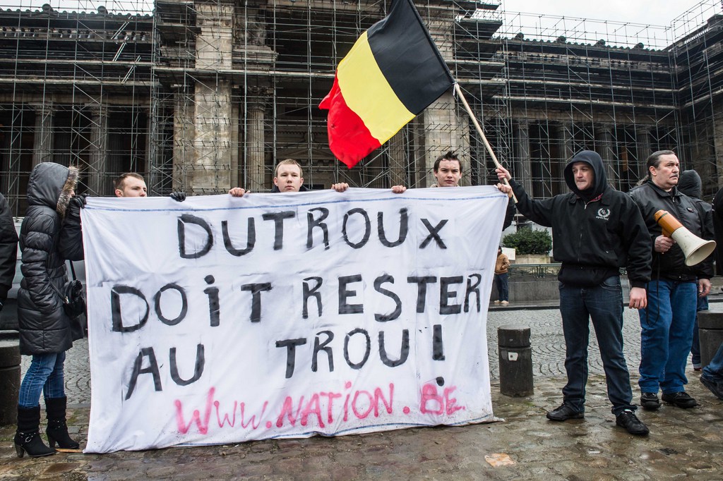Demonstrators hold a banner as they protest at the Palace of Justice in Brussels, Monday Feb. 4, 2013. Belgium's child killer Marc Dutroux, the man responsible for several rapes and deaths in the 1990's, appeared before the sentencing court after he requested electronic home arrest. The banner reads in French: " Dutroux has to stay in jail". (AP Photo/Geert Vanden Wijngaert)