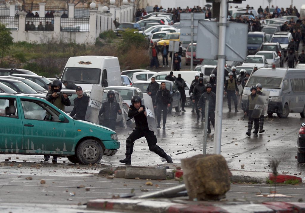 Tunisian riot police clash with protesters ( unseen) next to the cemetery where thousands of Tunisians are gathered to attend the funeral of slain opposition leader Chokri Belaid, near Tunis, Friday Feb. 8, 2013.  The Wednesday Feb. 6 assassination of prominent government critic Chokri Belaid plunged the country into one of its deepest political crises since the overthrow of the dictatorship in 2011. (AP Photo/Amine Landoulsi)