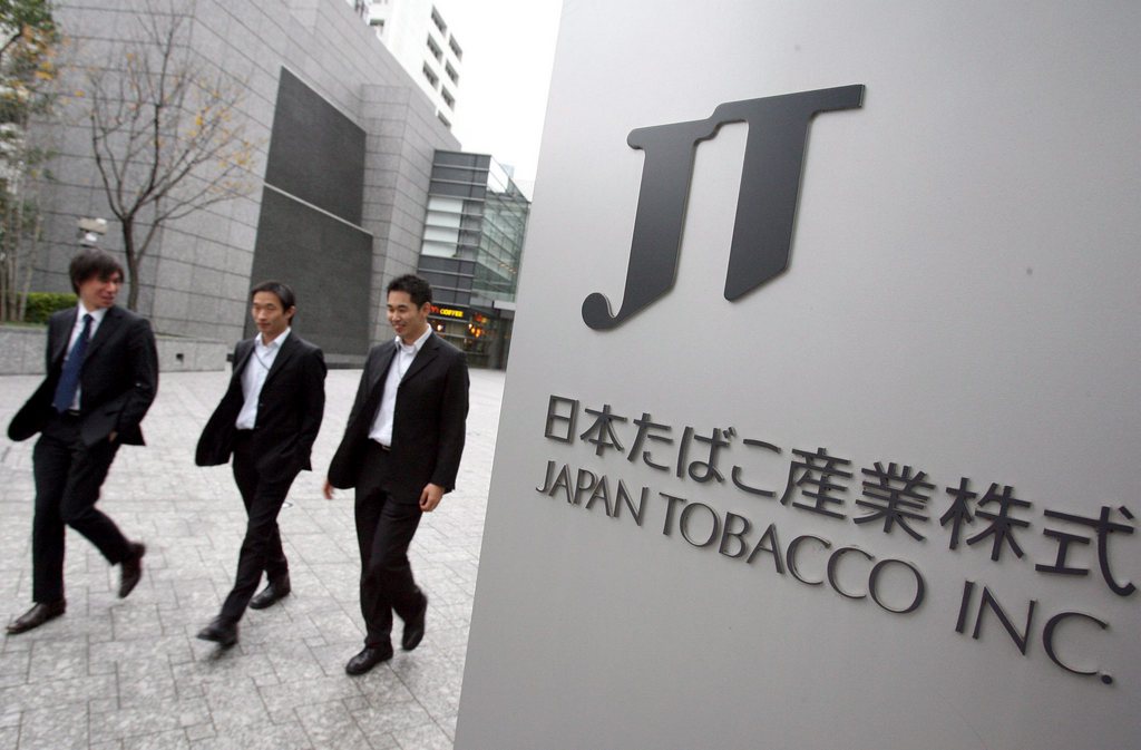 Des hommes d'affaire japonais, devant l'entrée des quartiers généraux de Japan Tabacco (JT)à Tokyo.