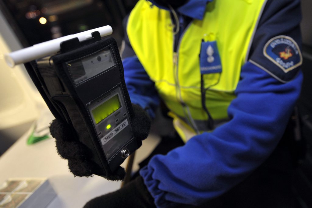 Un gendarme genevois presente un ethylometre dans le cadre d'un vaste controle routier pour l'alcoolemie, tot ce samedi 19 decembre 2009 a Geneve.  (KEYSTONE/Martial Trezzini)