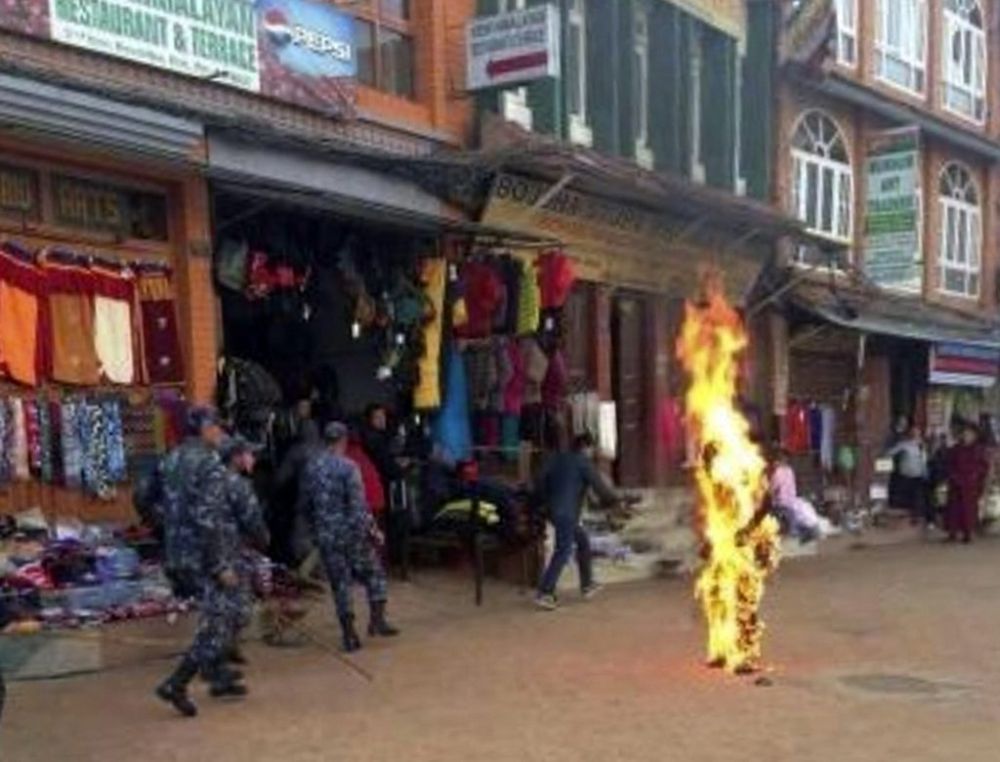 Nepalese policemen rush as a Tibetan monk burns after he set himself on fire in Katmandu, Nepal, Wednesday, Feb. 13, 2013. The Tibetan monk doused himself with gasoline and set himself on fire in Nepal's capital Wednesday in what is believed to be the latest self-immolation to protest Chinese rule in Tibet. Nearly 100 Tibetan monks, nuns and lay people have set themselves on fire in various countries, mostly in ethnic Tibetan areas inside China, since 2009.( AP Photo)