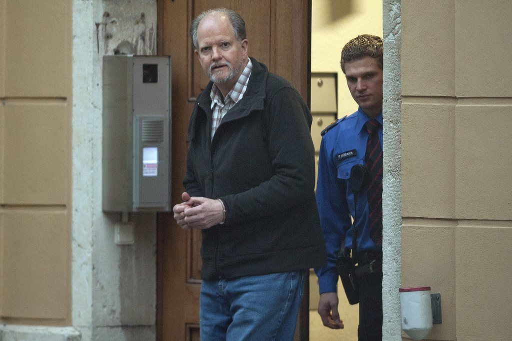 Peter-Hans Kneubuehl, menotté, suivi d'un policier, se rend dans la salle du tribunal d'arrondissement de Bienne