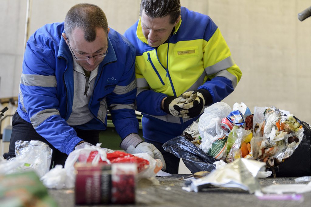Des employes du service assainissement de la ville de Lausanne cherchent des indices dans un sac poubelle noir, non conforme, afin de retrouver son proprietaire ce samedi 12 janvier 2013 a Lausanne. 