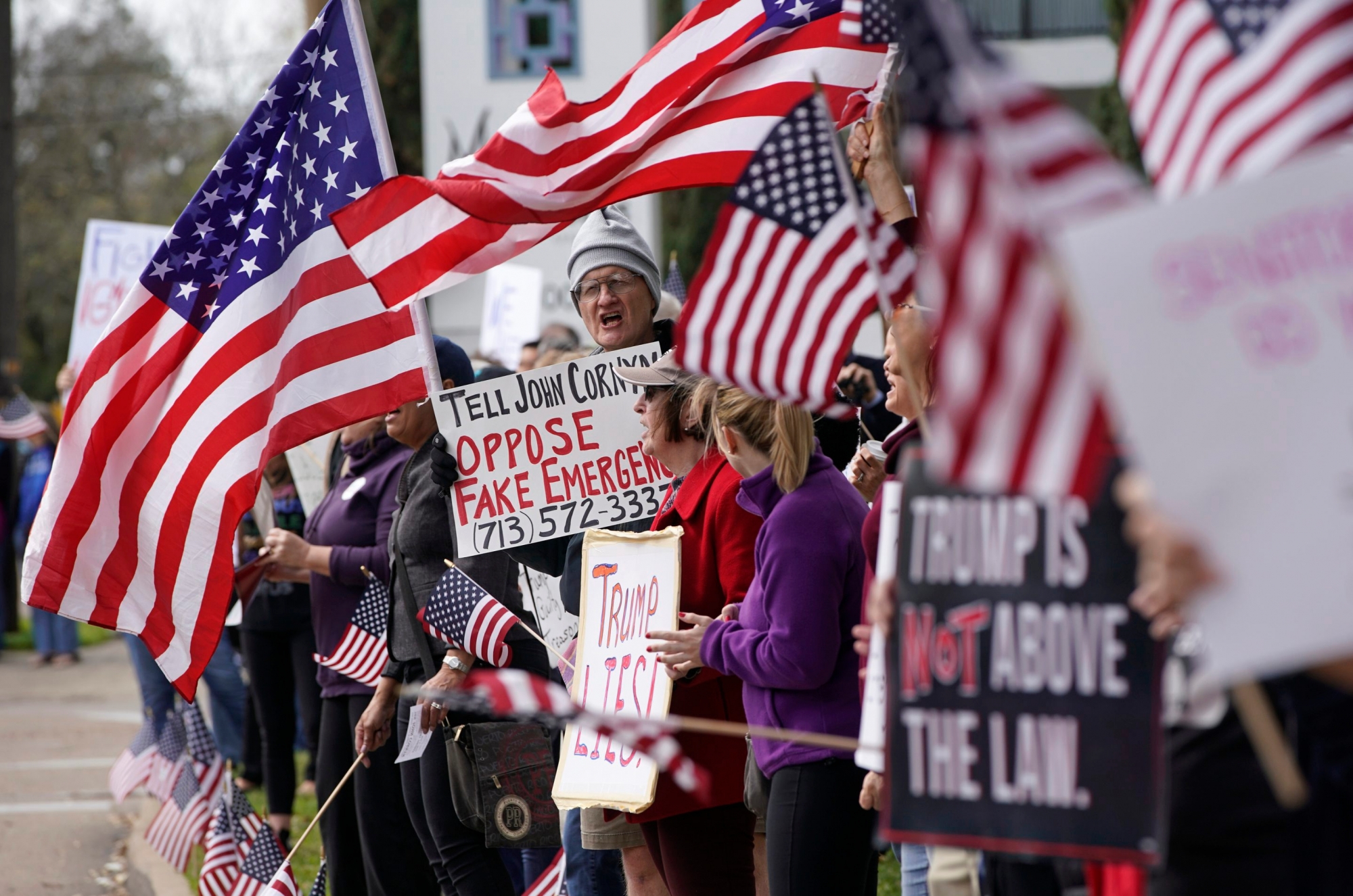 Alex McDonald of Houston, center, stands among protesters rallying along Memorial Drive outside the Houston office of Senator John Cornyn Monday, Feb. 18, 2019, in Houston. The event was part of nationwide protests against the national emergency declaration by President Donald Trump. (Melissa Phillip/Houston Chronicle via AP) Cornyn Protest