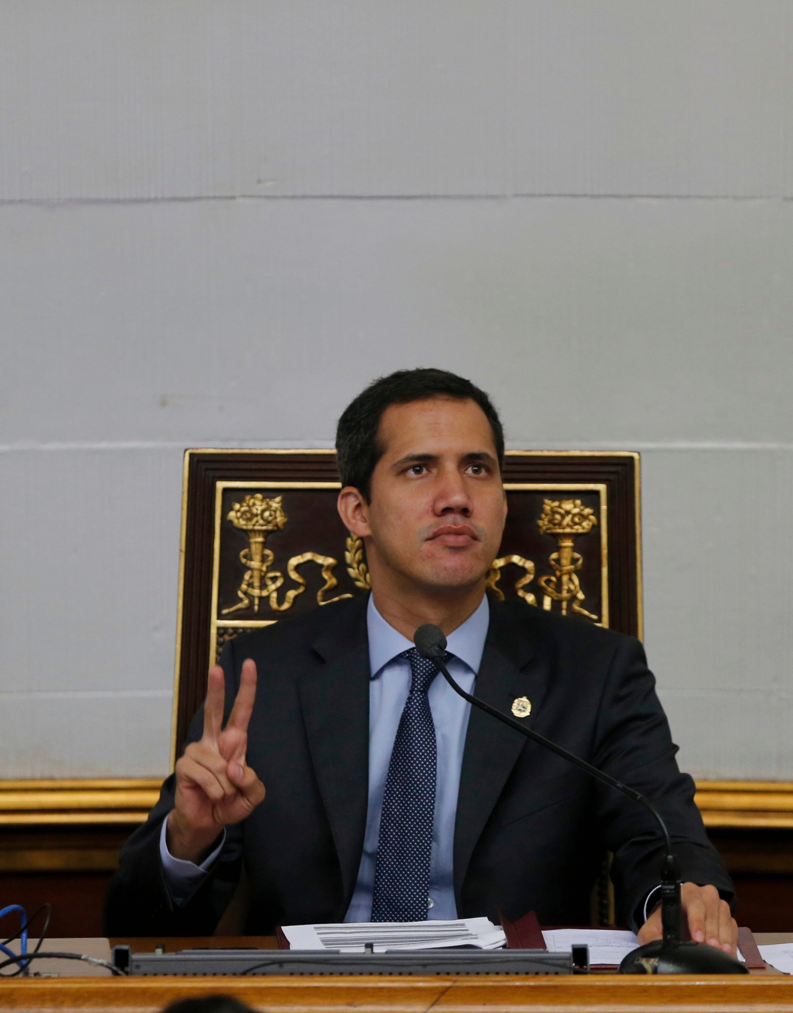 Juan Guaido, President of National Assembly and self-proclaimed interim president makes a victory sign during a session of the National Assembly in Caracas, Venezuela, Tuesday, April 2, 2019. Venezuela's chief justice on Monday asked lawmakers of the rival pro-government National Constituent Assembly to strip Guaido of his parliamentary immunity, taking a step toward prosecuting him for alleged crimes as he seeks to oust President Nicolas Maduro.(AP Photo/Fernando Llano) Venezuela Political Crisis