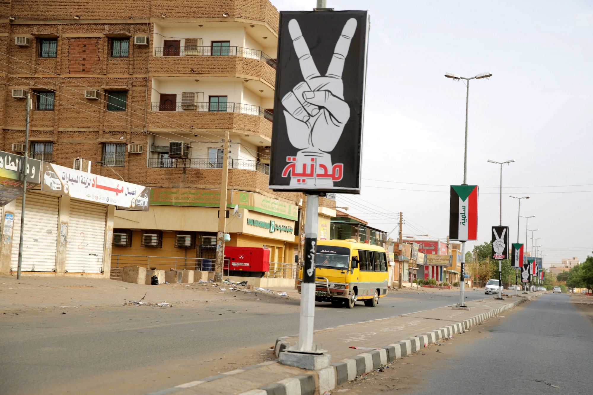 epa07640403 Vehicles drive on an almost deserted street near placards hanging on lighting poles reading in Arabic 'civilian' and 'peaceful' during the third day of 'Civil Disobedience' campaign in Khartoum, Sudan, 11 June 2019. According to local sources, several shops and banks remained closed and streets almost deserted on the third day of a 'Civil Disobedience' campaign called by Sudanese protest group in the wake of a deadly attack on protesters. The Sudanese Professionals Association (SPA) said the campaign would run until a civilian government was put in charge by the country's ruling generals.  EPA/MARWAN ALI SUDAN CIVIL DISOBEDIENCE