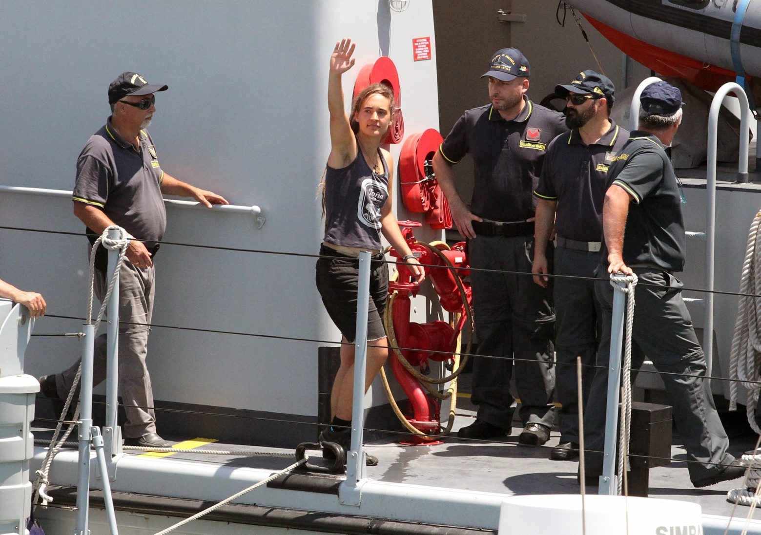 epa07686965 Rescue ship 'Sea-Watch 3' captain Carola Rackete (C), who is being held on charges of abetting immigration and ramming a police cutter, waves to spectators as she arrives in Porto Empedocle, Italy, 01 July 2019. German captain Carola Rackete was arrested on 29 June reportedly after violating orders from the Italian Finance Police and entering the port of Lampedusa while ramming a patrol boat on migrant rescue ship 'Sea-Watch 3'.  EPA/PASQUALE CLAUDIO MONTANA LAMPO ITALY MIGRATION SEA WATCH