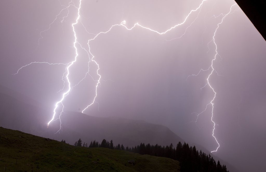 Blitzsalven entladen sich ueber der Alp Nadels oberhalb Trun im Buendner Oberland, in der Nacht vom Dienstag auf den Mittwoch, 23. August 2012. (KEYSTONE/Arno Balzarini)