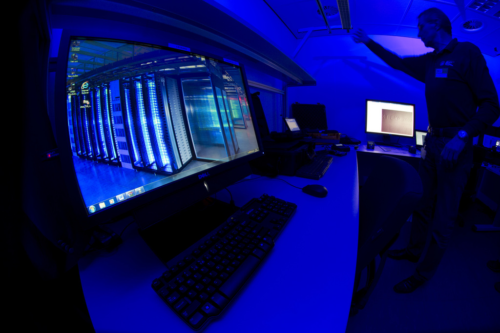A member of the Cybercrime Center turns on the light in a lab during a media tour at the occasion of the official opening of the Cybercrime Center at Europol headquarters in The Hague, Netherlands, Friday Jan. 11, 2013. The lab is housed in a cage of Faraday and is used amongst others to analyze computer hard disks, mobile phones and smart phones. (AP Photo/Peter Dejong)
